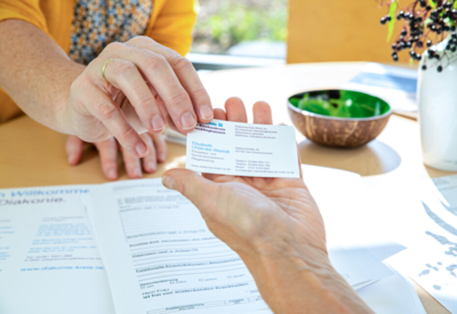 Eine Hand reicht einer anderen Hand eine Visitenkarte